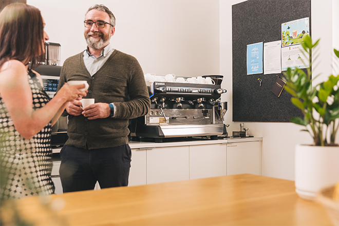 employees standing around the office coffee machine