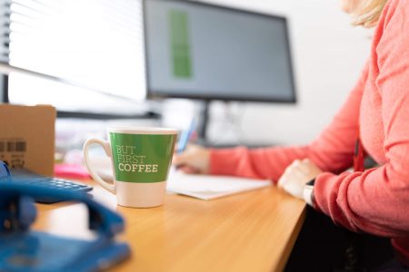 Cup of coffee on a computer desk
